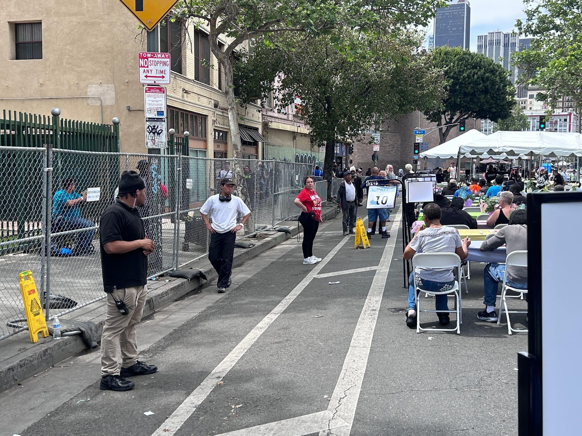 Two PSLA Worldwide officers working the perimeter fence line beside the seated dining area at the Los Angeles Mission